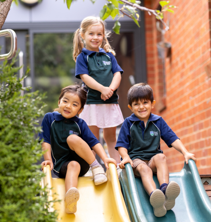 Three children playing on slide